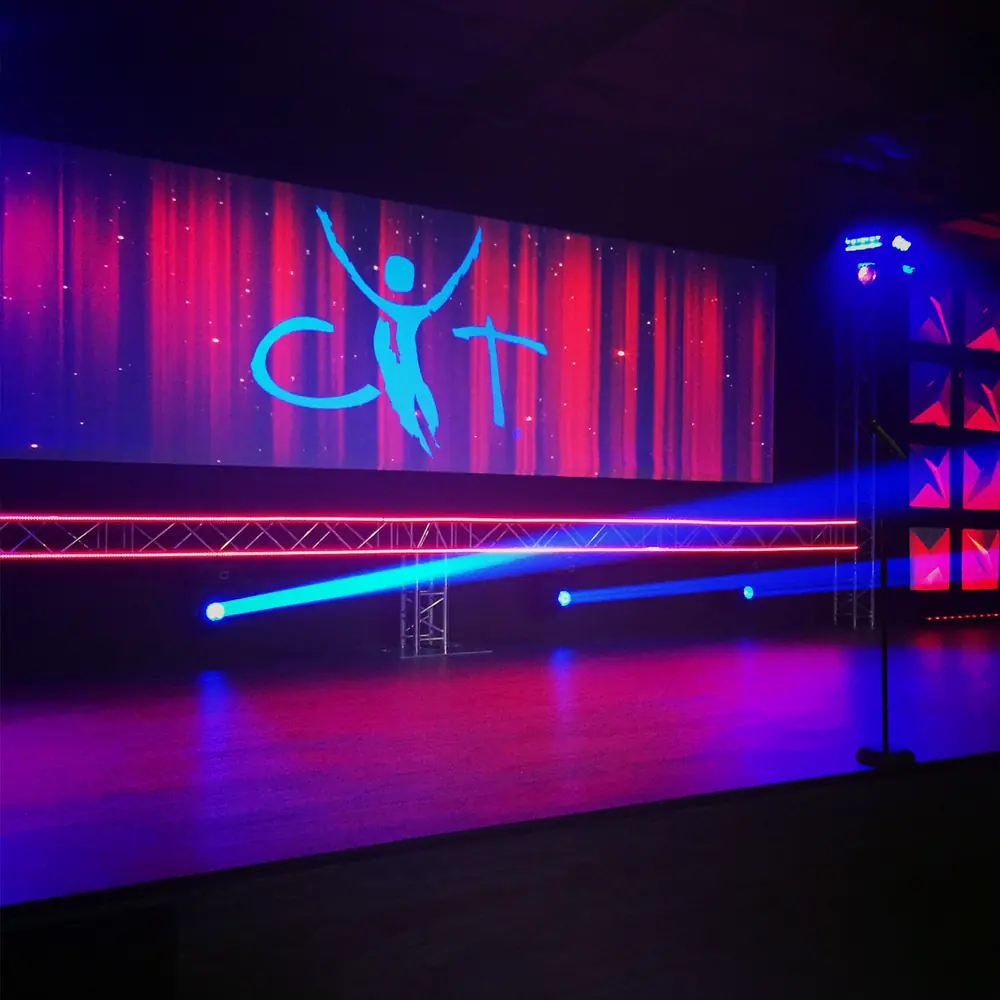 Stage lit by an LED wall and moving lights, with the Gilson Technical logo